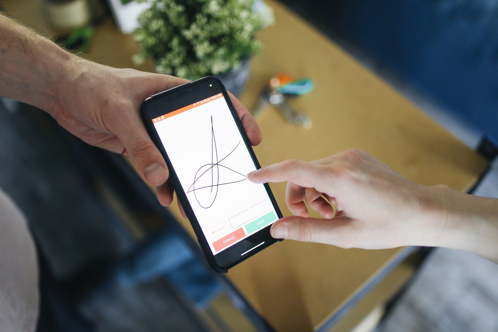 A client signing with a finger on a phone held out to them