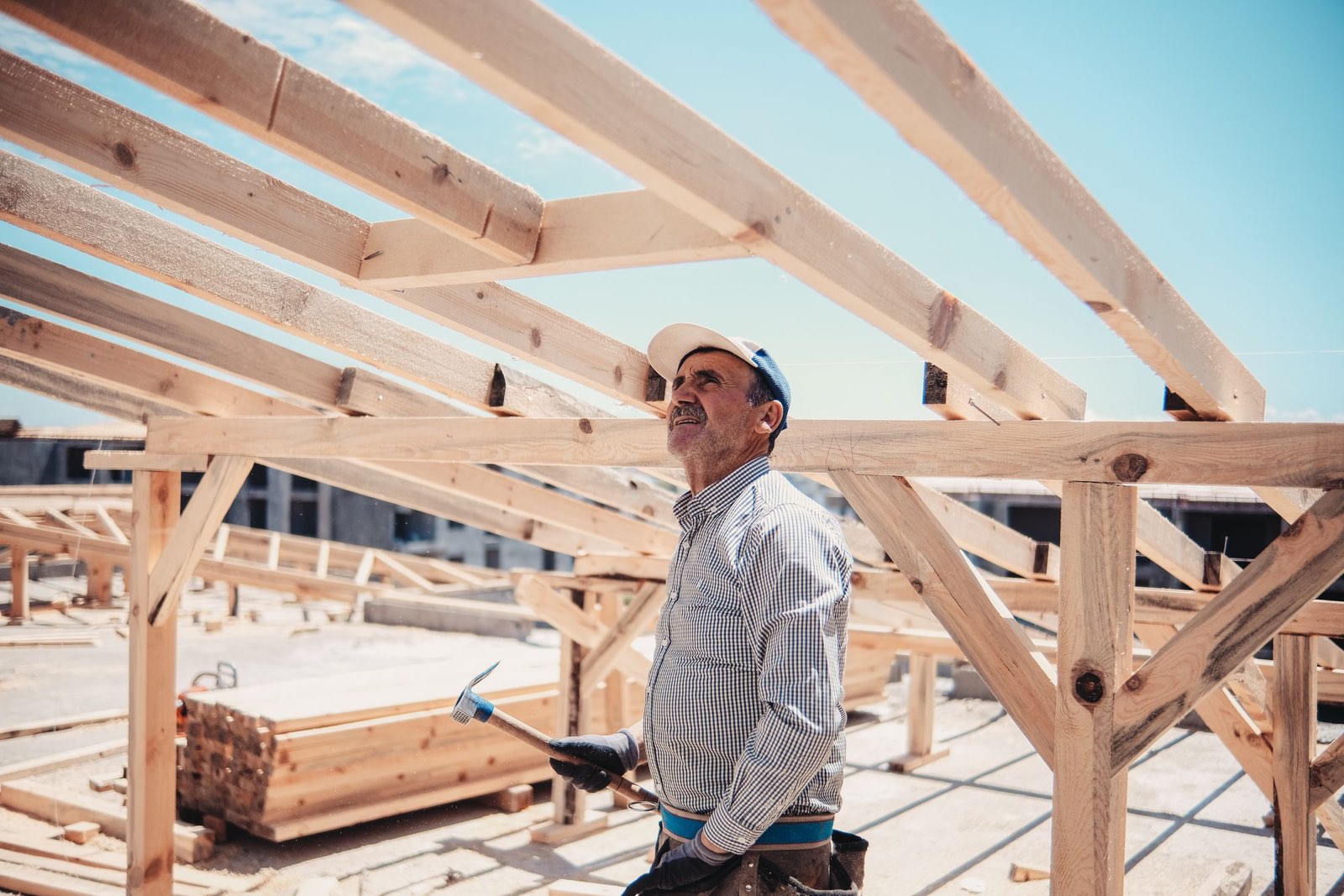 A builder looking up at a new timber roof frame